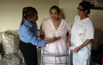 CHCA Registered Nurse, Jeannette Mitchell demonstrating safety precautions to worker and client. 